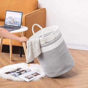 Minimalist woven cotton rope storage basket in grey and white with handles for home laundry