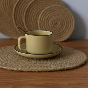 Detailed view of round braided jute placemats with natural woven texture on wood table