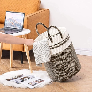 Close-up of woven cotton rope storage basket with dual handles in a modern home setting