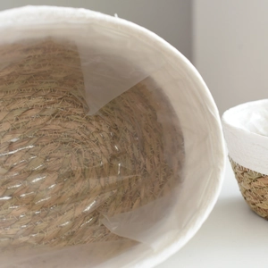 Oval woven seagrass plant basket with white trim and waterproof plastic lining