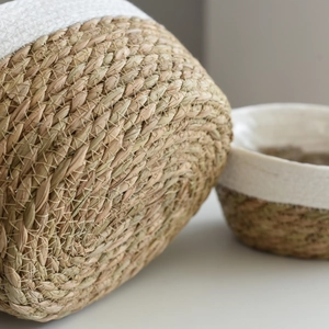 Handwoven oval straw planter basket made of seagrass and white cotton rope in Nordic style