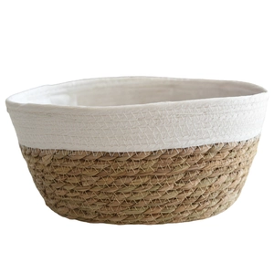 Oval woven straw plant pot with white cotton stitching in Nordic minimalist style