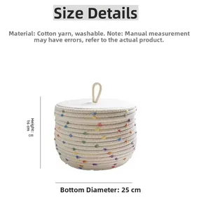 Detail showing white cotton rope basket with pom-poms, lid handle, 25cm base, and 16cm height