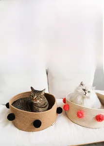 Detail of handwoven cotton rope cat bed with decorative pompoms for cozy pet comfort