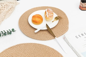 Close-up of woven jute placemat with natural fiber texture on minimalist breakfast table