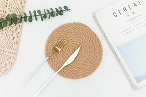 Detailed top view of natural jute placemat with spiral weave texture and gold cutlery