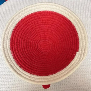 Top-down view of a red and cream cotton rope woven basket with spiral texture