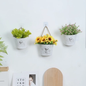Set of 3 vintage wall-mounted iron buckets with artificial sunflowers and green plants