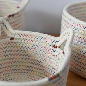 Detail of woven cotton rope storage basket with colorful rainbow zigzag stitching texture