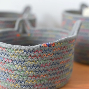 Macro shot of colorful zigzag stitching on a premium grey woven cotton rope storage basket