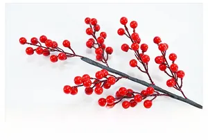 Close-up of artificial red holly berries with vibrant glossy finish on brown branches