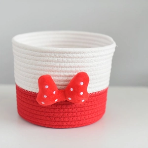 Close-up of red and white cotton rope woven storage basket with polka dot bowknot decoration