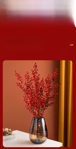 Detailed view of realistic red winterberry stems in a glass vase for home decoration