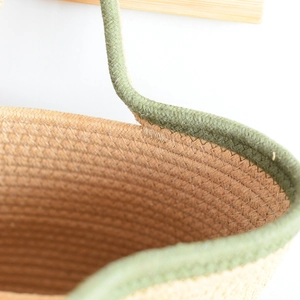 Detail of handwoven cotton rope bag showing green stitching and natural fiber texture