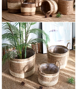 Detail of woven straw plant baskets with handles and waterproof liners for home decor