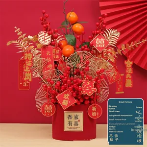 Close-up of festive red holly berries and golden ginkgo leaves in a red wedding planter