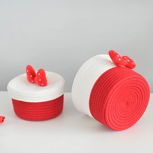 Close-up of woven cotton rope storage baskets with red polka dot bows for home organization