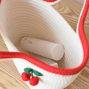 White cotton woven tote bag with red cherry accents and wavy edges for beach holidays