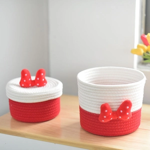 Detail of woven cotton storage baskets with red polka dot bow in cartoon style