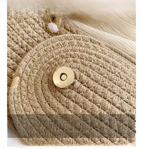 Detail of premium light gold metal magnetic clasp on a natural woven straw summer bag