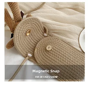 Detail showing the magnetic snap closure on the cute straw bag with bunny ear decor