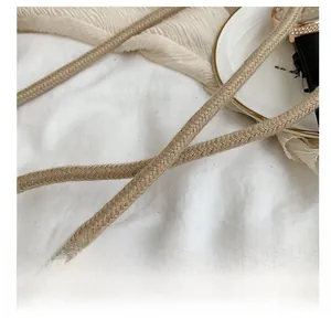 Close-up of tight woven texture and durable shoulder strap for beige straw beach bag