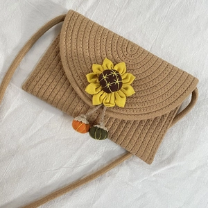 Handwoven straw shoulder bag with sunflower and pumpkin accents for summer beach outings