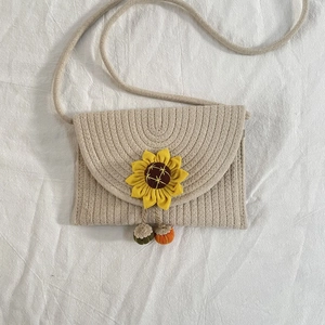 Handmade woven crossbody straw bag with sunflower accent and fruit charms for summer beach
