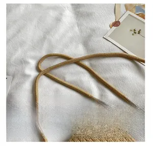 Detailed close-up showing the thick woven strap and texture of the straw beach bag