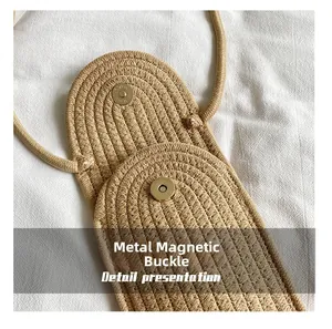 Detailed macro view of the metal magnetic buckle on the woven crossbody beach bag