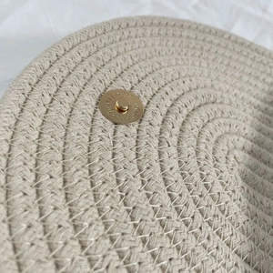 Detailed macro view of woven beige cotton rope bag texture and magnetic gold clasp
