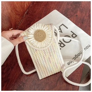 Detail of hand-woven phone bag featuring a large daisy and colorful zigzag stitching on wood