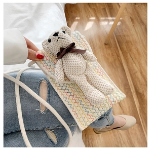 Detail of hand-woven crochet crossbody phone bag with a 3D teddy bear charm and colorful zigzag