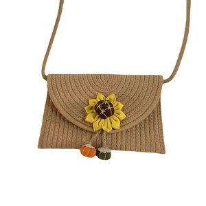 Handmade woven straw crossbody bag with sunflower decor and pumpkin charms for beach