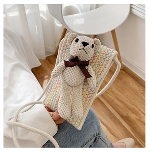 Detail of a beige crochet mini crossbody bag featuring a cute teddy bear and colorful embroidery