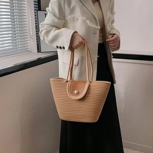 Detailed view of hand-woven tote bag with elegant pearl clasp and leather trim closure