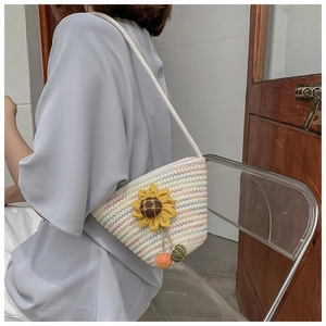 Detail of woven straw bucket bag featuring a 3D sunflower and colorful small charms