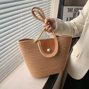 Woven straw tote bag with khaki texture, brown leather flap and pearl buckle detail