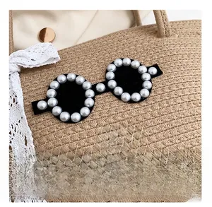 Détail du sac en coton kaki avec lunettes de soleil en perles et broderie lèvres rouges