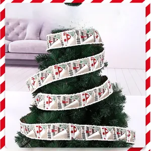 Detail of burlap Christmas ribbon with red house and green tree patterns on tree