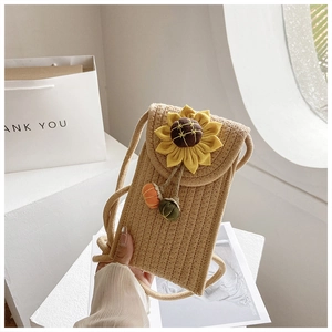 Detail of woven straw crossbody phone bag with sunflower ornament and soft rope strap
