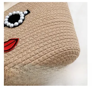 Détail du sac en coton tisse avec ornements de perles et écusson brodé en forme de lèvres