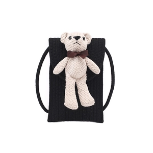 Cute black straw woven shoulder bag with a small beige knit bear and brown bow decoration