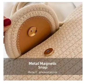 Close-up of golden magnetic buckle on brown leather flap and woven cotton bag detail