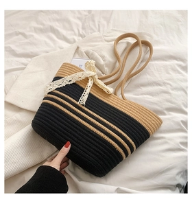 Détail du sac de plage tissé à la main avec rayures brun foncé et un nœud en dentelle blanche