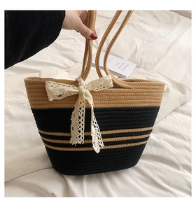 Détail du sac de plage tissé à la main avec un grand nœud en dentelle et design contrasté