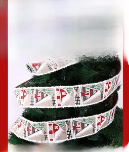 Close-up of rustic Christmas ribbon with red cabin and tree prints on pine branches