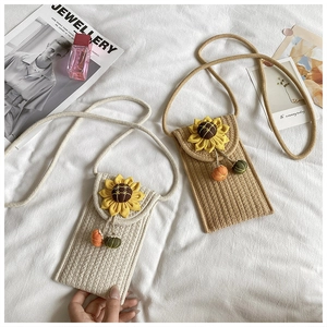 Detail showing two woven straw bags with sunflower appliques and pumpkin tassels