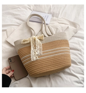 Détail du sac de plage tressé à la main avec nœud en dentelle beige et motif à rayures