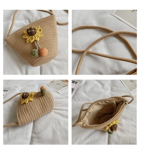 Detail view of woven straw bucket bag with sunflower accents and metal zipper closure